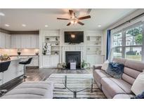 Inviting living room with fireplace, custom built-ins, and modern furnishings adjacent to an open-concept kitchen at 791 Belrose Dr, Smyrna, GA 30080