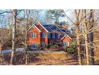 Brick house with a dark roof and landscaping at 7715 Bold Springs Xing, Cumming, GA 30041