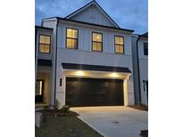 Stunning two-story home with white brick exterior and a black garage door at 1937 Westwind Street (Lot 158), Lawrenceville, GA 30043