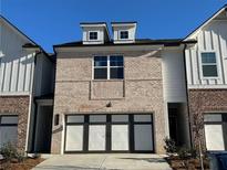 Charming brick townhome featuring dormer windows and an attached two-car garage at 222 Depot Landing Rd # 58, Auburn, GA 30011