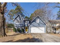 Charming two-story home featuring a blue exterior, attached garage, and a welcoming yellow front door at 1878 Hamby Place Nw Dr, Acworth, GA 30102