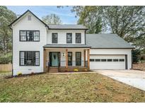 Two-story white farmhouse with black trim, gray roof, and a charming front porch at 425 Shepard Sw Dr, Marietta, GA 30064