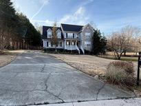 Charming two-story home boasts a stone accent, covered porch, and long driveway at 6945 Autumn Hills Dr, Cumming, GA 30028