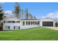 Charming white brick home with a welcoming front porch and well-maintained lawn at 554 Briggs Sw Cir, Lilburn, GA 30047
