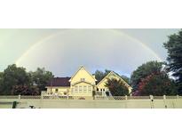 House exterior featuring a two-story home with a large yard and a rainbow in the background at 1417 Doe Valley Dr, Lithonia, GA 30058
