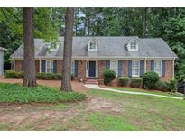 Brick ranch home with blue shutters, landscaped yard, and inviting front entrance at 5513 N Peachtree Rd, Dunwoody, GA 30338