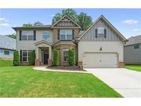 Two-story house with brick and siding, landscaped lawn, and driveway at 6235 Stillwood Ln, Cumming, GA 30041