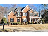Two-story brick home with a large front yard and mature trees at 2968 Winterthur Close Nw, Kennesaw, GA 30144