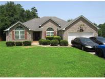 Brick ranch house with attached garage, landscaping, and a basketball hoop at 3971 S River Ln, Ellenwood, GA 30294