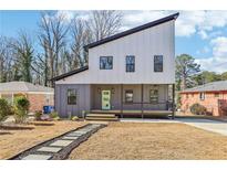 Modern two-story house with gray and white siding, a light green door, and a stone path at 665 Ferris Sw St, Atlanta, GA 30310