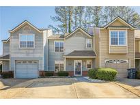 Tan and gray townhome with two-car garage and landscaped front at 3284 Long Iron Pl, Lawrenceville, GA 30044