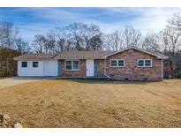 Brick ranch house with attached garage and spacious yard at 24 Echo Ridge Dr, Powder Springs, GA 30127