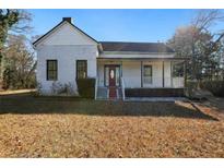 Charming white farmhouse with a front porch and expansive yard at 1512 Flat Shoals Rd, Atlanta, GA 30349