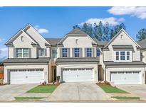 Charming townhome featuring a light brick exterior, attached garage, and well-maintained landscaping at 4090 Cavalier Way, Duluth, GA 30097