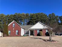 Brick and vinyl siding home with mature landscaping and a spacious yard at 1703 Mission Park Dr, Loganville, GA 30052