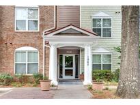 Inviting condo entrance featuring a covered entryway and brick and siding accents at 1965 Nocturne Dr # 1209, Alpharetta, GA 30009