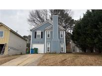 Cute blue house with a white garage door and well-maintained lawn at 6660 Buckingham Ct, Norcross, GA 30093