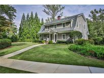 Gray shingled home with a large front yard, walkway, and mature trees at 1658 E Clifton Ne Rd, Atlanta, GA 30307