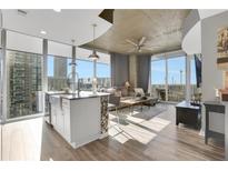 Open living area with city views, hardwood floors, and modern furniture at 855 Peachtree Ne St # 1703, Atlanta, GA 30308