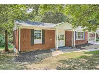 Brick ranch house with a covered porch and well-maintained lawn at 895 Kings Grant Nw Dr, Atlanta, GA 30318