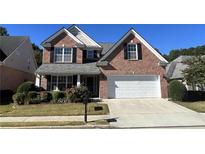 Brick two-story house with a white garage door and landscaping at 2280 Hickory Station Cir, Snellville, GA 30078