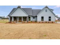 Two-story farmhouse with gray siding, covered porch, and brick accents at 628 Ridge Rd, Dallas, GA 30157