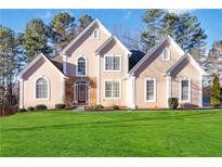 Two-story house with light-pink stucco and a manicured lawn at 4140 Cherry Ridge Walk, Suwanee, GA 30024