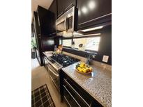 Modern kitchen featuring stainless steel appliances, granite countertops, and sleek, dark cabinetry at 972 Dekalb Ne Ave # 203, Atlanta, GA 30307