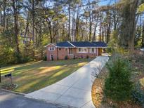 Brick ranch house with a large driveway and mature trees at 1915 Audubon Ne Dr, Atlanta, GA 30329