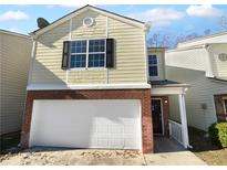 Tan two-story house with white garage door and dark shutters at 5165 Hanover St, Atlanta, GA 30349