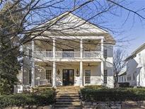 Charming two-story home showcasing a welcoming front porch with a swing and meticulous landscaping at 6725 Cross Gate St, Cumming, GA 30040