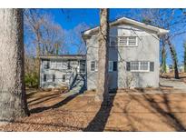 Gray two-story house with a large yard and mature trees at 2668 Woodfen Dr, Ellenwood, GA 30294