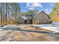 Brick home with a large driveway, partially covered in snow at 570 Pleasant Grove Rd, Mcdonough, GA 30252