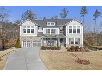 Two-story house with gray siding, stone accents, and a three-car garage at 612 Taymack W, Woodstock, GA 30188