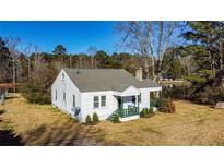 White house with green porch sits on a spacious lot near a pond at 8235 Spence Rd, Fairburn, GA 30213