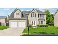 Charming two-story home featuring a two-car garage, a well-manicured lawn, and classic architectural details at 4450 Millenium View Ct, Snellville, GA 30039