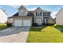 Two-story house with a two-car garage and a well-maintained lawn at 4450 Millenium View Ct, Snellville, GA 30039