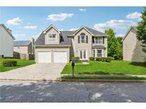 Charming two-story home featuring a manicured lawn, two-car garage, and inviting front entrance at 4450 Millenium View Ct, Snellville, GA 30039