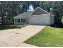 Newly built home with gray siding, two-car garage, and a well-manicured lawn at 4694 E Glen Ridge E Cir, Winston, GA 30187