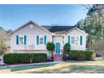 Tan house with teal shutters, landscaping, and a two-car garage at 1890 Tribble Ridge Dr, Lawrenceville, GA 30045