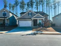 Gray house with white garage door and landscaping; located on a tree-lined street at 730 Lanarck Way, Peachtree City, GA 30269