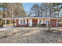 Brick ranch house with carport and landscaped yard at 8298 Holly Dr, Jonesboro, GA 30238