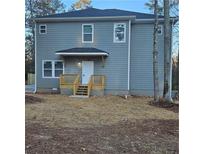 Two-story house with gray siding, wood deck, and a backyard at 7190 Buck Creek Dr, Fairburn, GA 30213