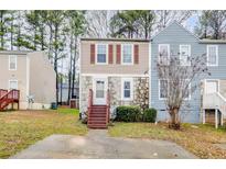 Tan and stone two-story townhome with brown front door and steps at 348 Red Oak Run, Marietta, GA 30008