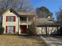 Two-story house with red accents, attached two-car garage, and a well-maintained lawn at 1402 Chelsea Downs Ne Ln, Conyers, GA 30013