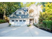 Two-story house with a white garage door and landscaped yard at 5490 Powers Overlook Ct, Atlanta, GA 30327