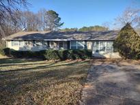 Ranch style home with mature landscaping and a long driveway at 155 Club Dr, Locust Grove, GA 30248