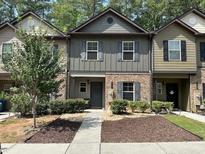 Two-story townhome with gray siding, brick accents, and a landscaped front yard at 4193 Shoals Ln, Union City, GA 30291
