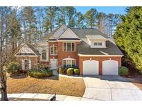 Brick house with 3-car garage, landscaping, and a paved driveway at 4008 Creekview Ridge Ct, Buford, GA 30518