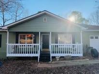 Ranch home with front porch, green siding, and a black door at 1638 River Trce, Auburn, GA 30011